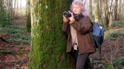 Béatrice appuyée sur un arbre à la recherche d'une belle photo